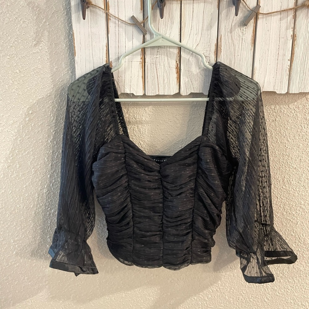 Black top with transparent sleeves.